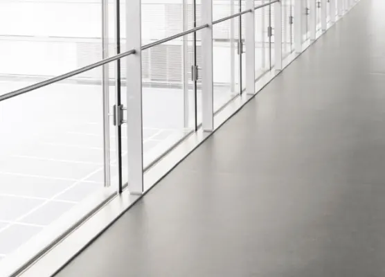 Pavimento continuo grigio in un corridoio vetrato
